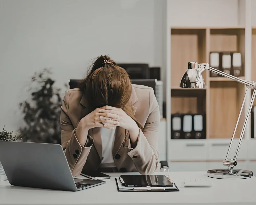 Femme épuisée au travail, montrant des signes de burnout féminin et de fatigue intense.